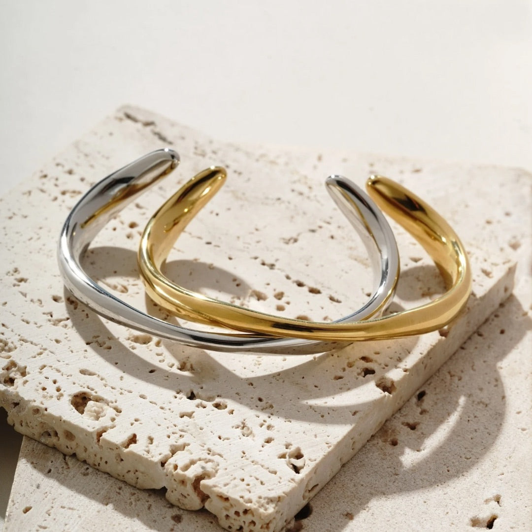 Adjustable gold bangle that varies in thickness. It’s water resistant and tarnish resistant. Available in gold and silver 