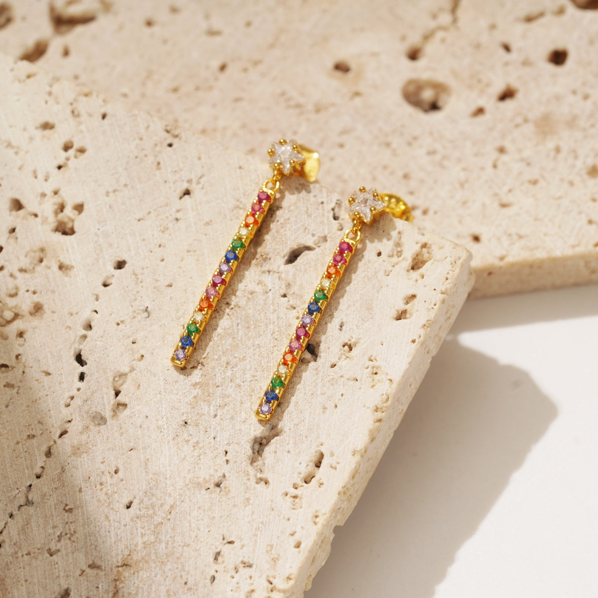 Playful and fun earrings that boast colour. The Lainey drop earrings are vibrant drop earrings that feature the colours of the rainbow hanging from a star stud. 