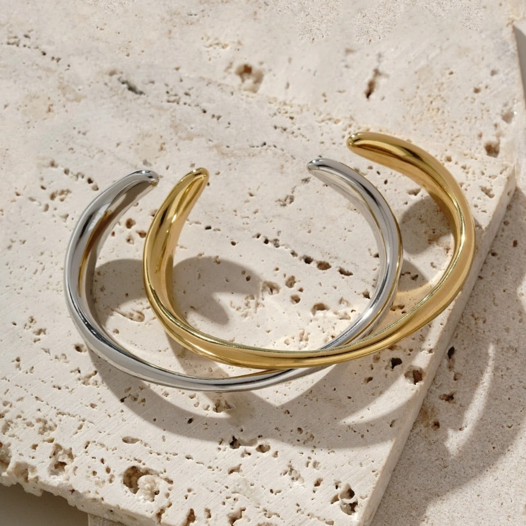 Adjustable gold bangle that varies in thickness. It’s water resistant and tarnish resistant 