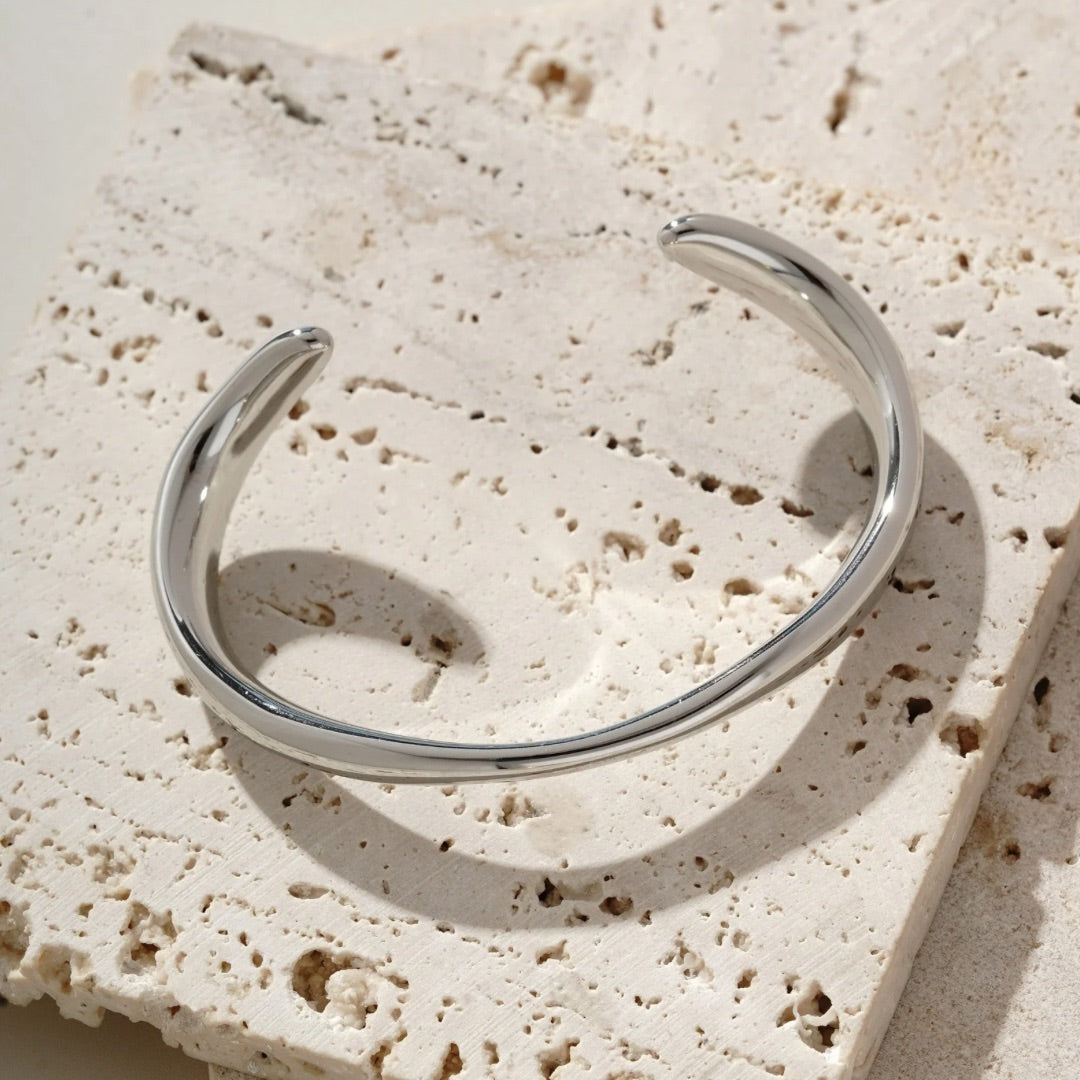 Adjustable silver bangle that varies in thickness. It’s water resistant and tarnish resistant 