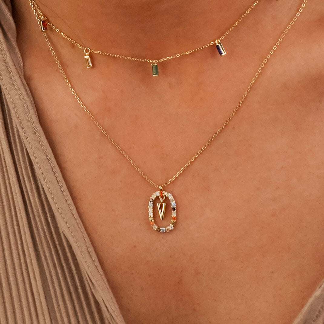Colourful initial necklace with floating V letter surrounded by a shinning halo. The chain is gold and it is made from high quality sterling silver.
