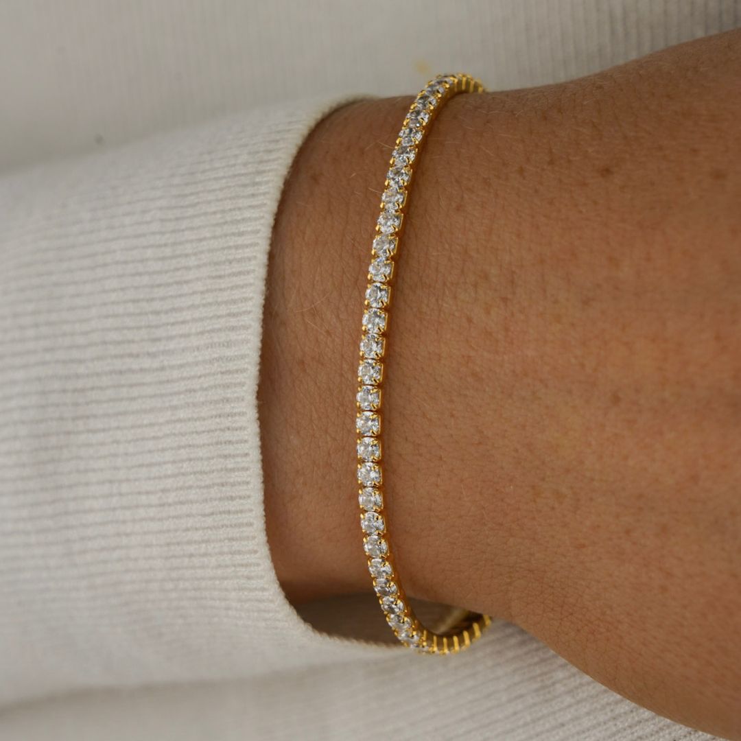 Crafted with meticulous precision, the Billie Tennis Bracelet showcases a seamless row of meticulously set gemstones that radiate brilliance and sparkle. Each stone, like a perfectly struck tennis ball, captures the essence of Billie Jean King's unwavering focus and unwavering determination on the court.