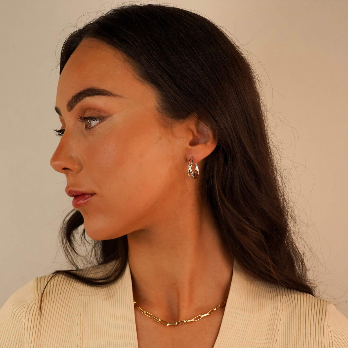 silver hoop earring with a celtic design. They are called the Fianna Earrings and they are inspired by Irish heritage. The Fianna earrings are photographed on a model.