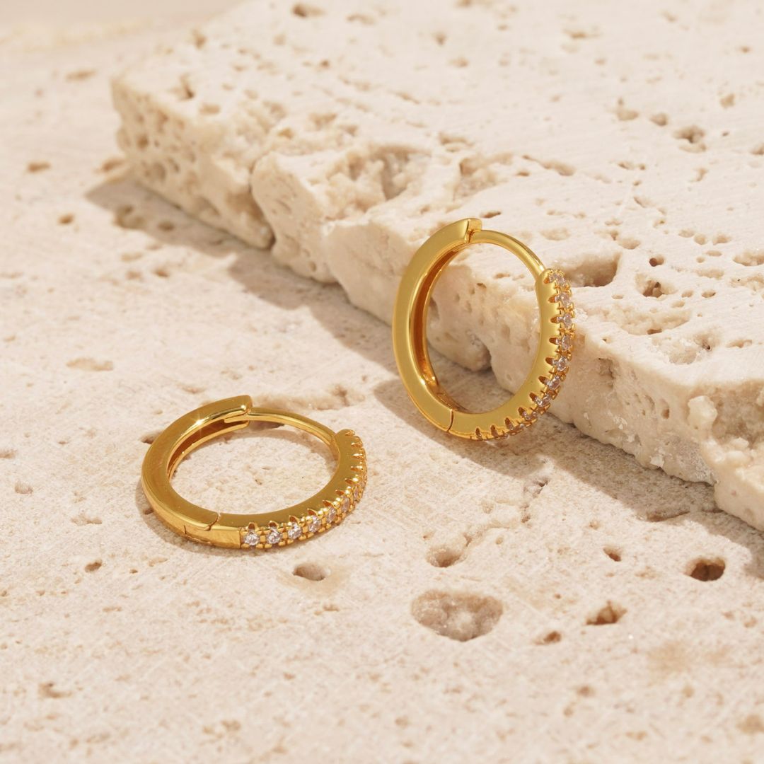 Gold hoop earrings adorned with glistening white stones perfect for gifting. From a small irish brand. 