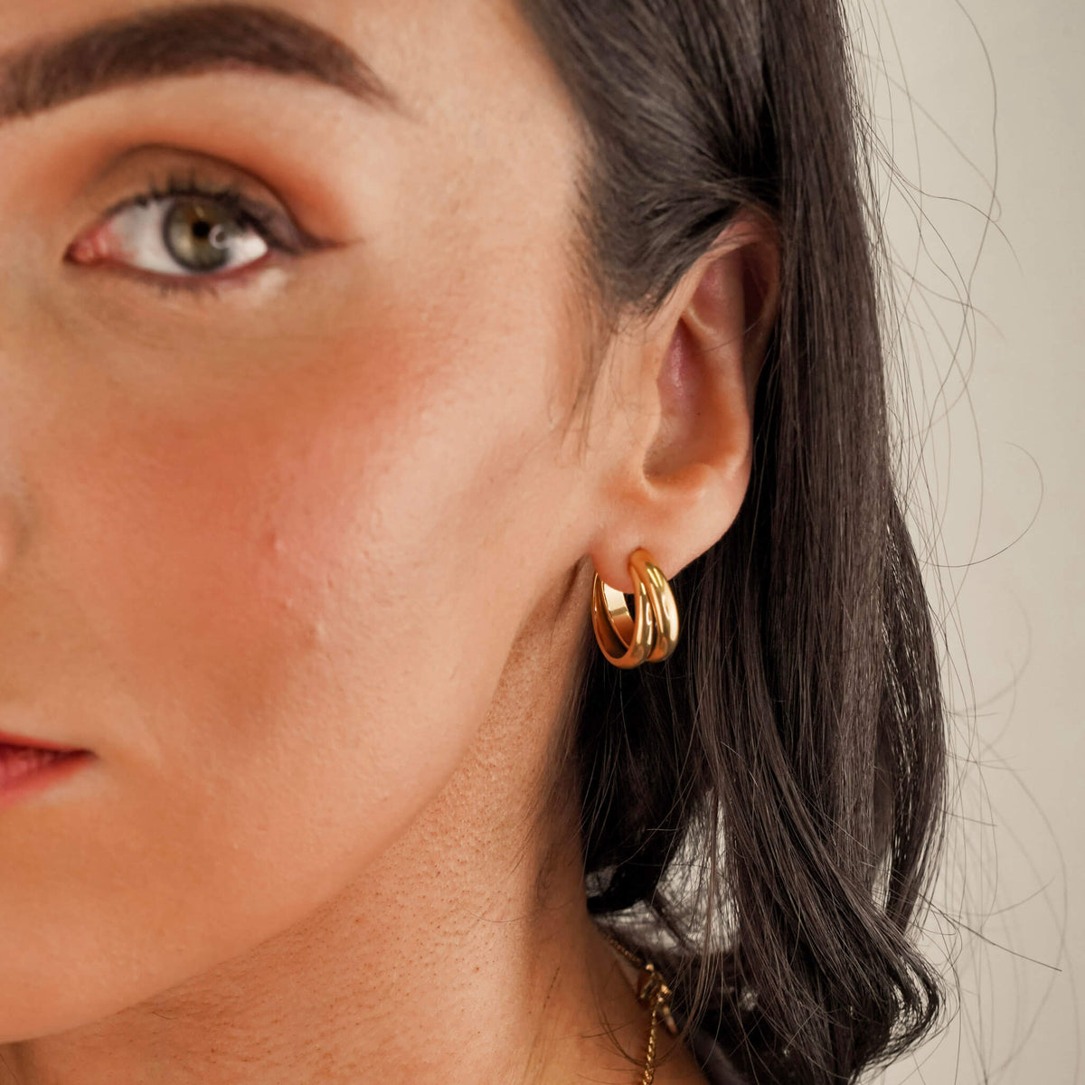 The 'Muse Hoops' from Mettle & Bloom - a pair of double band gold hoop earrings. Crafted with precision, the hoops feature a steel-plated finish for durability and a lustrous appeal. A seamless blend of timeless elegance and contemporary style, these earrings offer a versatile accessory to elevate your look. Available now at Mettle & Bloom, the Muse Hoops embody modern sophistication with their exquisite design.