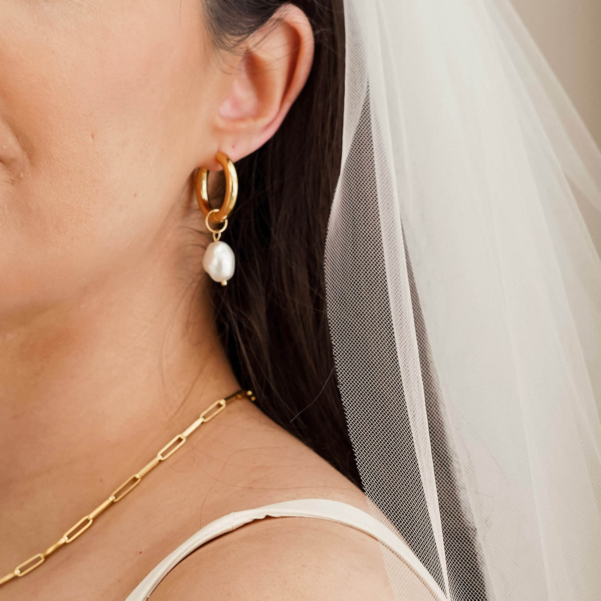 Bride is wearing gold hoop earrings with a dangling pearl. The pearl can be removed.